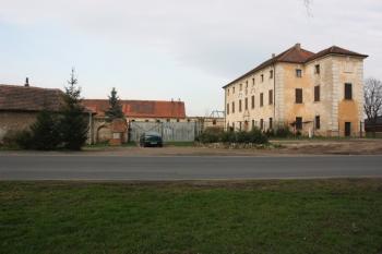 Pohled od jihu na zámek (vpravo) a zdevastovaný hospodářský dvůr ( © Ivan Grisa 04/2011)