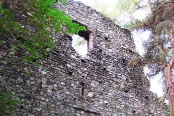 Západní (vnější) stěna budovy se střílnami v prvním a okny sálu v druhém patře ( © Filip Matoušek 08/2004)
