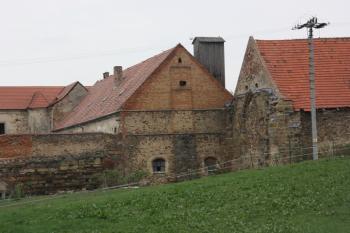 Jihozápadní roh hospodářského dvora, štít stodoly vpravo obsahuje okno někdejší kapitulní síně ( © Ivan Grisa 04/2011)