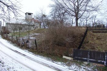 Jihovýchodní, dnes nejvyšší část centrálního pahorku. Silnice vede jižním příkopem, v pozadí požární zbrojnice stojící v jihozápadním rohu pahorku ( © Roman Řezáč 12/2005)