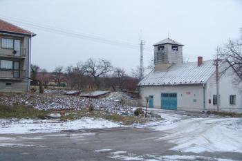 Celkový pohled na centrální pahorek, který je vidět v pozadí mezi obytným domem a požární zbrojnicí ( © Roman Řezáč 12/2005)
