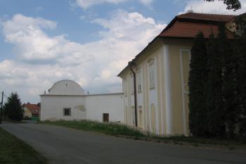 bok zámku s napojením soustavy hospodářských stavení, uprostřed zazděný původní vjezd (zachováno kamenné ostění) (© Jaroslav Špiroch, 05/2018)
