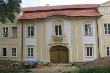 pohled na hlavní průčelí zámku z návsi se vstupním portálem a nad ním erby stavebníka a jeho manželky (© Jaroslav Špiroch, 05/2018)