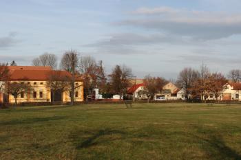 Severní strana návsi, za domy jsou patrné výrazně vyšší střechy stodol ( © Ivan Grisa 12/2009)