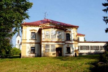 Hlavní budova zámku, v pozadí kostel sv. Jana Křtitele ( © Pavel Vítek 05/2006)
