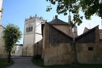 Budovy přiložené k někdejšímu ohrazení kostelního areálu, v pozadí zvonice (© Ivan Grisa, 09/2006)