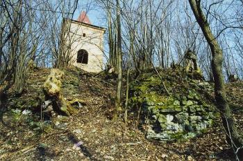 Zbytky obvodové hradby hradu na jižní straně, v pozadí novodobá zvonice ( © Filip Matoušek 11/2001)