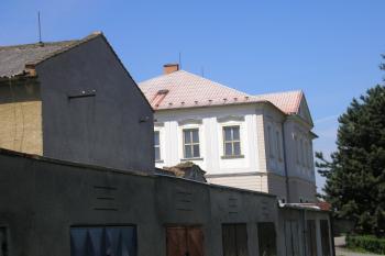 pohled od východu na hospodářskou budovu, bývalý vjezd do dvora a zámek ( © Ondřej Štěpánek 06/2006)