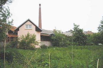 pohled od západu na místo nástupní plošiny tvrze (v místě růžové budovy), v pozadí patrná střecha hlavní budovy tvrze (č.p. 223) ( © Ondřej Štěpánek 06/2006)