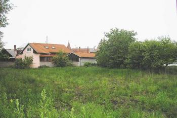 pohled od jihozápadu přes bývalý příkop na místo nastupní plošiny tvrze (v místech růžového stavení) ( © Ondřej Štěpánek 06/2006)