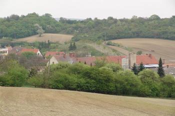 Pohled od západu na tvrziště, nad střechami domů ( © Roman Řezáč 04/2006)