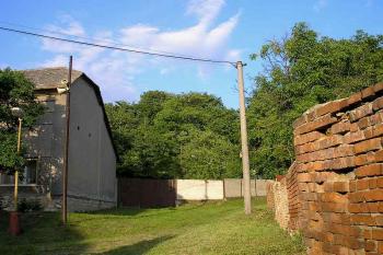 pohled z obce na kopec, na kterém stojí tvrz, vlevo ústí cesta ke tvrzi ( © Ondřej Štěpánek 06/2006)