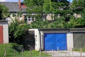 nad gárážemi se nachází stromy porostlý zbytek tvrziště, v pozadí jižní strana dvora (mladší tvrze) ( © Ondřej Štěpánek 06/2006)