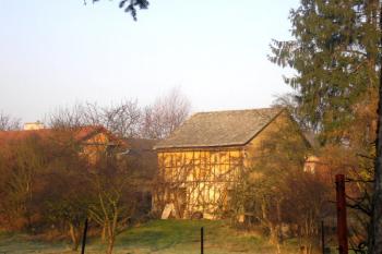pohled od kostela na centrální pahorek tvrze (žlutá věžovitá stavba) ( © Ondřej Štěpánek 03/2007)
