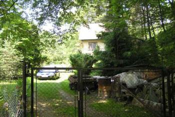 POhled od jihu na západní svah a příkop hradu, ve kterém stojí víkendová chata (© Jan P. Štěpánek 06/2006)
