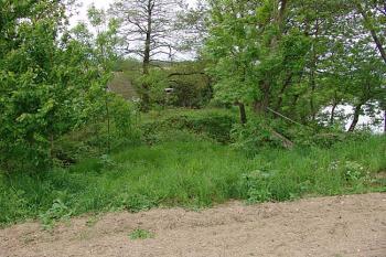 Pohled z planiny přes příkop na vyvýšené místo jádra ( © Roman Řezáč 05/2006)