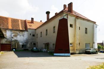 Budova tvrze od jihozápadu, v popředí původní pilíř, při opravě zakrytý šindelovou lepenkou ( © Filip Matoušek 07/2006)