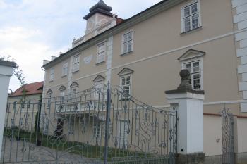 vjezd s krásně kovanými vraty do zámku, vpravo jižní průčelí zámku s balkonem a věžičkou (© Jaroslav Špiroch, 05/2018)