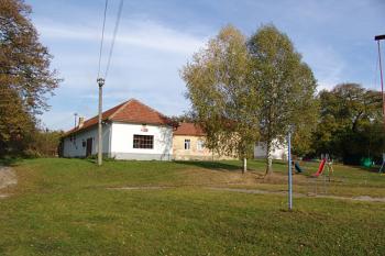 Požární zbrojnice (bílá budova) a za ní bývalá škola, stojící v místě tvrze ( © Roman Řezáč 11/2006)