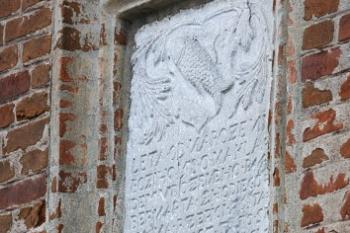 Deska s erbem Hodějovských, dokládající rozšíření dvora v r. 1580, dnes umístěná ve štítě mladšího severního křídla ( © Filip Matoušek 12/2006)
