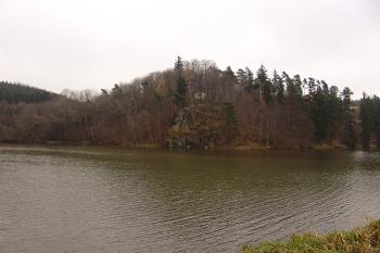 Pohled na skalnatý výběžek s hrádkem a kaplí přes rybník od zámku ( © Roman Řezáč 12/2006)