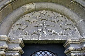 tympanon nad portálem s reliéfem krucifixu a dvou ležících postav ( © Pavel Zany Komárek 18.4. 2007)