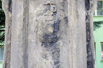 detail podstavce sochy s latinským nápisem a zanikajícím církevním znakem ( © Jan P. Štěpánek 06/2007)