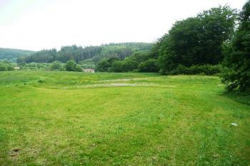 pohled na prostor před hradní skálou s viditelnou terénní prohloubeninou po zaniklém stavení ( © Jan P. Štěpánek 06/2008)