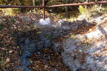 nelegálním výkopem odkrytý vnitřní líc pláštové hradby s příčnou zdí ( © Pavel Zany Komárek 29.10. 2005)