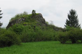 skála vedle kostela - poslední pozůstatek bohaté těžby vápence. Vedle této skály se rozkládá travnatá plošina, kde byl v roce 1976 veliký opuštěný lom se dvěma jezírky. (© Rodochrozit, 05/2013)