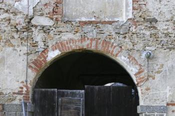 Průjezd do bývalé zahrady se zbytky bosovaného portálu, nad ním barokní rámec se zbytky výzdoby ( © Filip Matoušek 12/2007)
