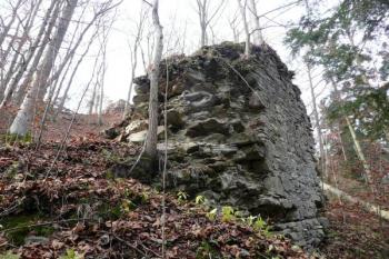 mohutný blok celistvého kusu hradby zadního hradu, který se kuriozně zachoval sesutý v dolní části svahu k zadnímu hradu ( © Jan P. Štěpánek 12/2009)