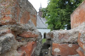 Průhled k druhotně osazenému románskému portálu skrz prasklou zeď (© Jan Večeřa, 06/2015)