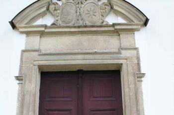Západní portál s aliančním erbem Trautmannsdorfů a Černínů (© Ivan Grisa, 07/2008)