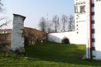 pozůstatek okružního příkopu zámku se zbytkem ohradní zdi a mostem přes příkop ( © Jan P. Štěpánek 05/2009)