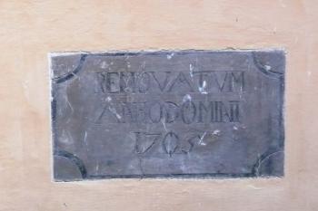 kamenná deska osazená ve stěně arkádové chodby nádvoří informující o obnově zámku po požáru v r. 1708 ( © Jan P. Štěpánek 05/2009)
