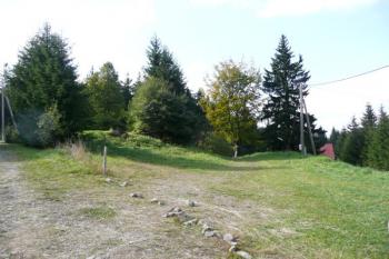 vlevo zarostlé základy bývalé vyhořelé Masarykovy chaty, vpravo střecha současné chaty ( © Jan P. Štěpánek 09/2008)