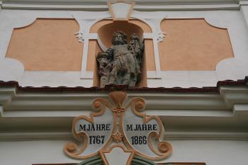 Socha patrona a kartuše s letopočty stavby a opravy ve štítě hlavního průčelí (© Ivan Grisa, 03/2009)