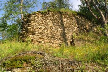 Zbytek mohutné čelní hradby, dnes největší nadzemní část zdiva hradu ( © Filip Matoušek 07/2006)