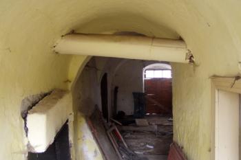 Chodba spojující vstupní síň se zadním východem, nalevo je patrný zbytek černé kuchyně. (© Matěj Kruntorád, 10/2010)